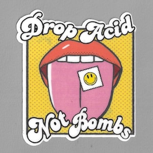 May include: A yellow and red cartoon image of a mouth with a tongue sticking out. The tongue has a yellow smiley face sticker on it. The text "Drop Acid Not Bombs" is written in white letters on a yellow background.