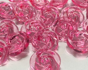 May include: A collection of translucent pink rose-shaped beads. The beads are clustered together, showcasing their detailed spiral design. The color is a vibrant, clear pink, and the beads appear to be made of glass or a similar material. These beads are ideal for jewelry making.