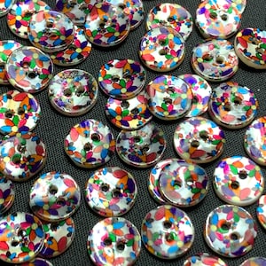 May include: A collection of colorful, round buttons with a floral design. The buttons have a glossy finish and feature a variety of colors, including red, orange, green, and purple. Each button has two or four holes for sewing.