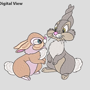 Puede incluir: Un diseño bordado con dos conejos de dibujos animados. Uno es marrón claro con un cuello rosa, y el otro es gris. El texto "Digital View" se encuentra en la esquina superior izquierda.