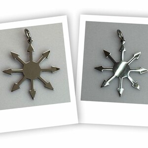May include: Two silver-colored pendants, each featuring a stylized eight-pointed star design with arrows pointing outwards. The pendants are displayed on a white background within a Polaroid-style frame, showcasing a unique, geometric jewelry piece.