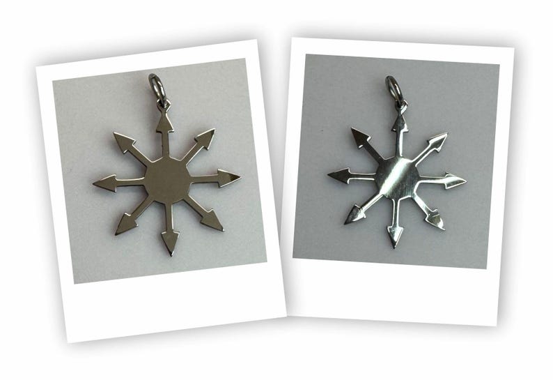 May include: Two silver-colored pendants, each featuring a stylized eight-pointed star design with arrows pointing outwards. The pendants are displayed on a white background within a Polaroid-style frame, showcasing a unique, geometric jewelry piece.