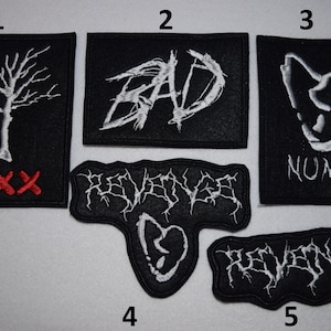 Puede incluir: Conjunto de 5 parches de hierro bordados negros con costuras blancas y rojas. Los parches presentan varios diseños, incluyendo un árbol, la palabra "BAD", una calavera y la palabra "REVENGE".