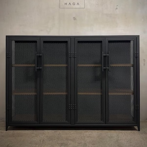 Puede incluir: Armario negro de metal con cuatro puertas y paneles de malla metálica. El armario tiene dos estantes en cada sección. El armario está etiquetado como "METALFUN HAGA".