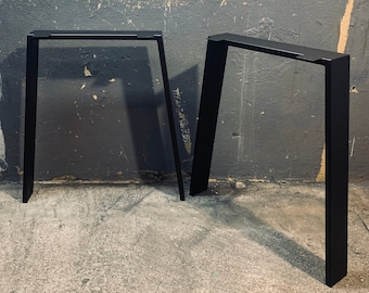 Könnte beinhalten: Zwei schwarze Metalltischbeine mit rechteckiger Form und leicht schrägem Design. Die Beine stehen auf einem Betonboden. Der Text "METALFUN" ist im Hintergrund sichtbar.