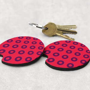 May include: Two red and black round beverage coasters with a purple circle pattern. The coasters are made of a soft, absorbent material and are perfect for protecting surfaces from condensation.
