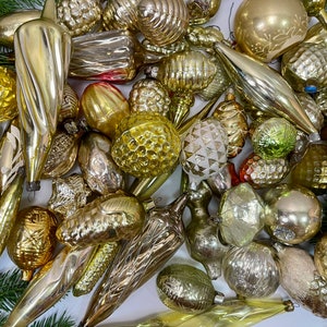 May include: A collection of vintage glass ornaments in various shapes and sizes, including stars, bells, and cones. The ornaments are all silver and gold in color and have a frosted finish. They are perfect for adding a touch of vintage charm to your Christmas tree.