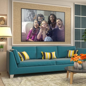 May include: A teal blue sofa with yellow and black striped throw pillows. The sofa is in a living room with a framed photo of a group of friends laughing and a coffee table with a vase of orange flowers.