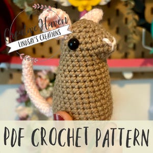 May include: A handmade crochet bunny in shades of brown and pink. The bunny has a black eye and a white nose. The text "Creative Haven Lindsay's Creations" is in a circle above the bunny. The words "PDF CROCHET PATTERN" are at the bottom.