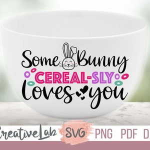 Puede incluir: Tazón de cerámica blanco con un gráfico de conejo y el texto "Some Bunny Cereal-Sly Loves You".