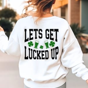May include: White sweatshirt with black text that reads "LETS GET LUCKED UP" with green shamrocks and beer mugs.