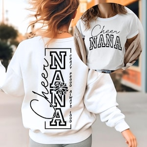 May include: A white long-sleeved sweatshirt and a white t-shirt featuring black text. The sweatshirt back displays the vertical text Cheer NANA with a pom-pom graphic and the words CRAZY PROUD ALWAYS LOUD. The t-shirt front features Cheer NANA.
