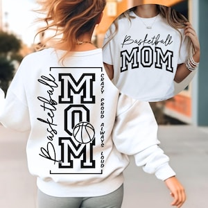May include: White sweatshirt and t-shirt with black text and a basketball graphic. The sweatshirt features the words "Basketball Mom" and "Mom" with a basketball. The t-shirt also says "Basketball Mom".