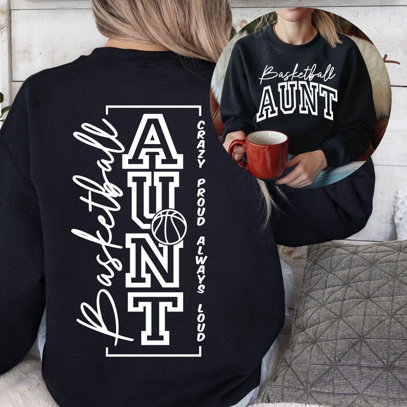 May include: Black sweatshirt with the words "Basketball AUNT" in white script and block letters. The back of the sweatshirt has the words "Basketball AUNT" and a basketball graphic. The words "Crazy Proud Always Loud" are printed vertically.
