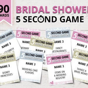 May include: A set of 90 cards for a bridal shower game called "5 Second Game: Bridal Edition". The cards are pink, blue, and beige with a floral pattern. Each card has a category and a prompt for the game.