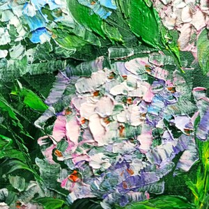 May include: Close-up of a painting of purple, white, and pink flowers with green leaves. The flowers are painted with thick brushstrokes, giving the painting a textured look.