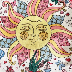 May include: A colorful illustration featuring a smiling sun with rays in shades of yellow, pink, and peach. The design includes hearts, flowers, a sailboat, and the text "SING YOUR OWN SPECIAL SONG". The artwork has a whimsical, folk art style.