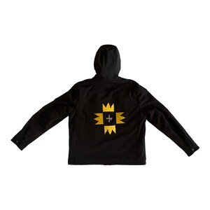 Puede incluir: Chaqueta negra con capucha y un dise&ntilde;o bordado en dorado en la espalda. El dise&ntilde;o presenta una cruz con una corona en cada punto.