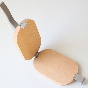 Puede incluir: Un fabricante de gofres de madera con un mango plateado. El fabricante de gofres est&aacute; abierto y listo para usarse.