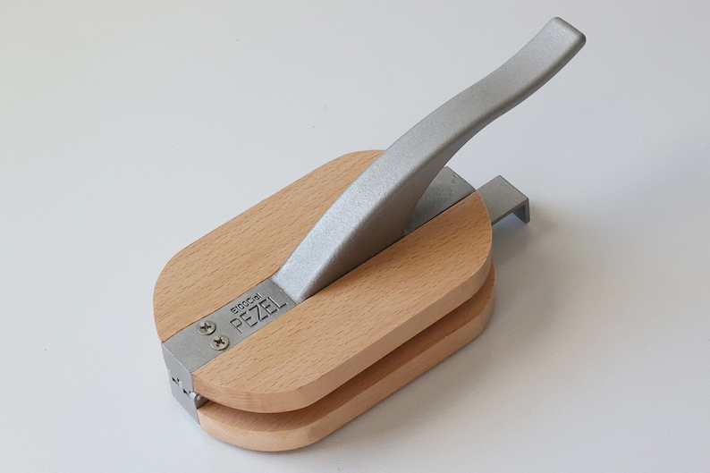 Puede incluir: Un cascanueces de madera con un mango plateado. El cascanueces est&aacute; etiquetado con "Pezel" y "Brooch".