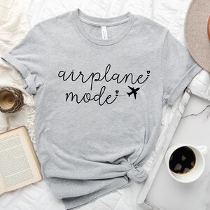 May include: Gray t-shirt with the text "airplane mode" in black cursive writing with a small airplane graphic and hearts.
