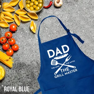 May include: Royal blue apron with white text that reads "Dad The Man The Myth The Grill Master" with a grill spatula and fork graphic.