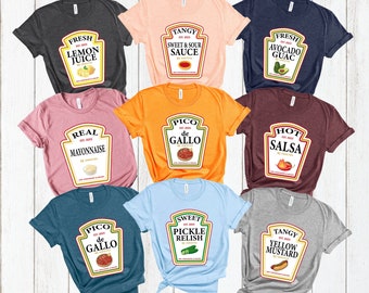 May include: Nine different t-shirts with various food-themed designs. Each shirt features a ketchup-style label with a different food item, such as lemon juice, avocado guac, real mayonnaise, pico de gallo, hot salsa, sweet pickle relish, and tangy yellow mustard.