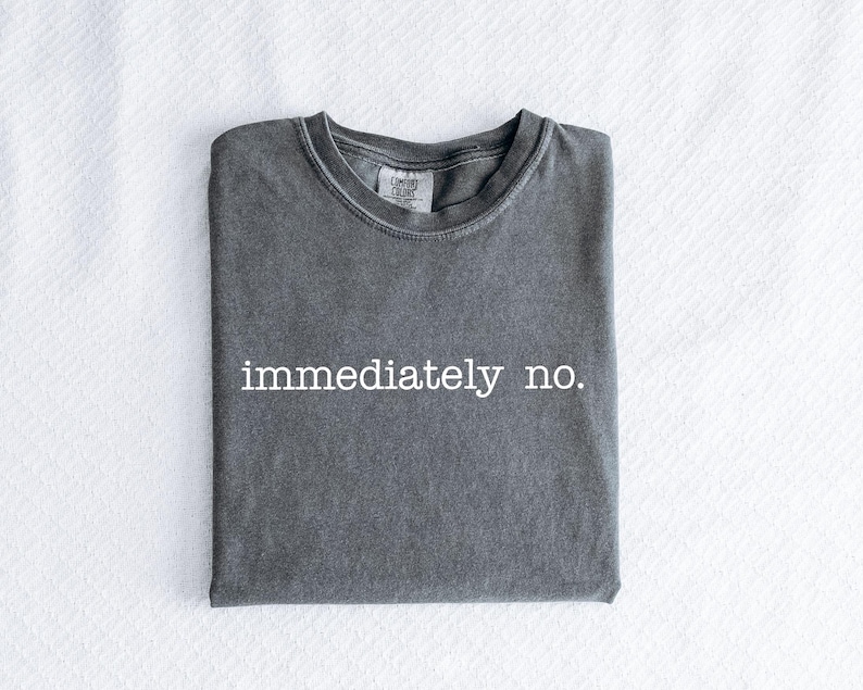 May include: A dark gray t-shirt with the text "immediately no." printed in white.