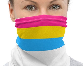May include: A white face mask with a horizontal stripe pattern in pink, yellow, and blue. The mask is worn by a person with blonde hair.