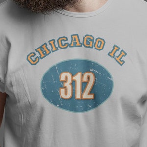May include: A gray t-shirt with a blue and orange circle graphic that says "CHICAGO IL 312" on it.