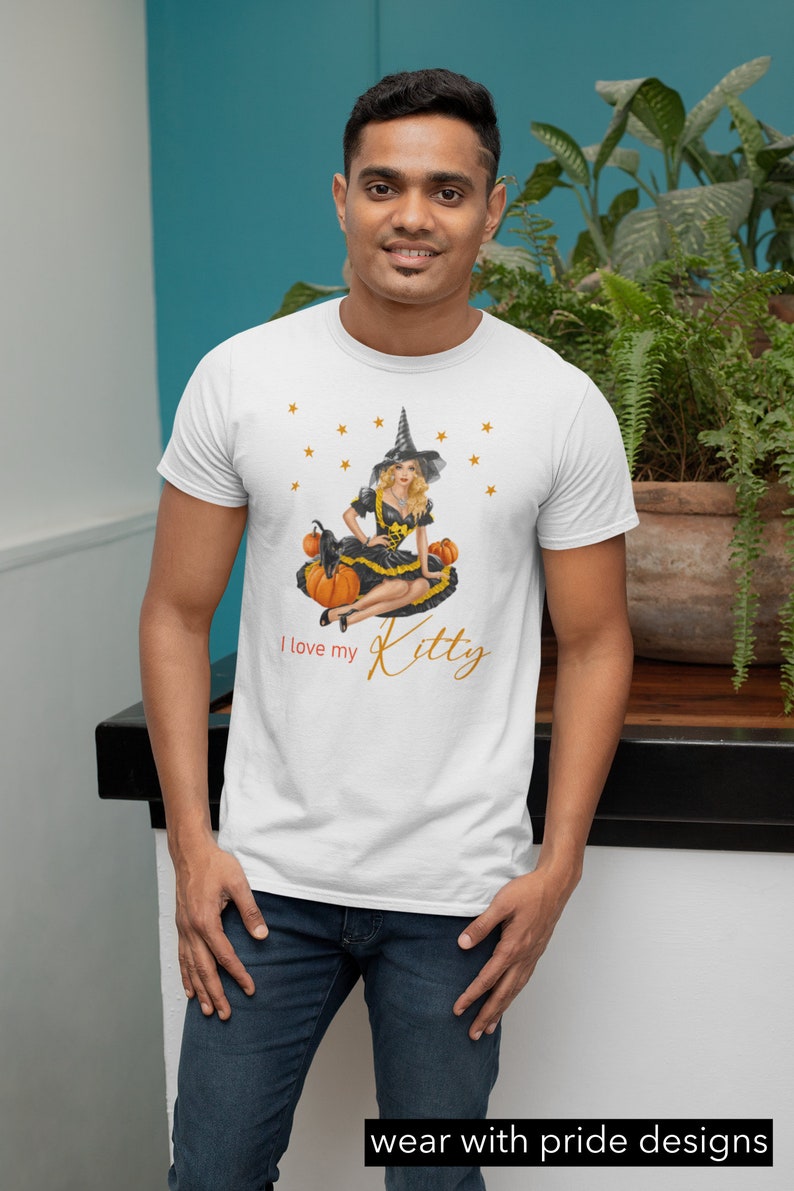 May include: White t-shirt with a graphic of a witch sitting on pumpkins with the text "I love my Kitty" in gold lettering.