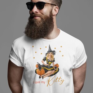 May include: White t-shirt with a graphic of a witch sitting on pumpkins with a black cat. The text "I love my Kitty" is printed on the shirt.