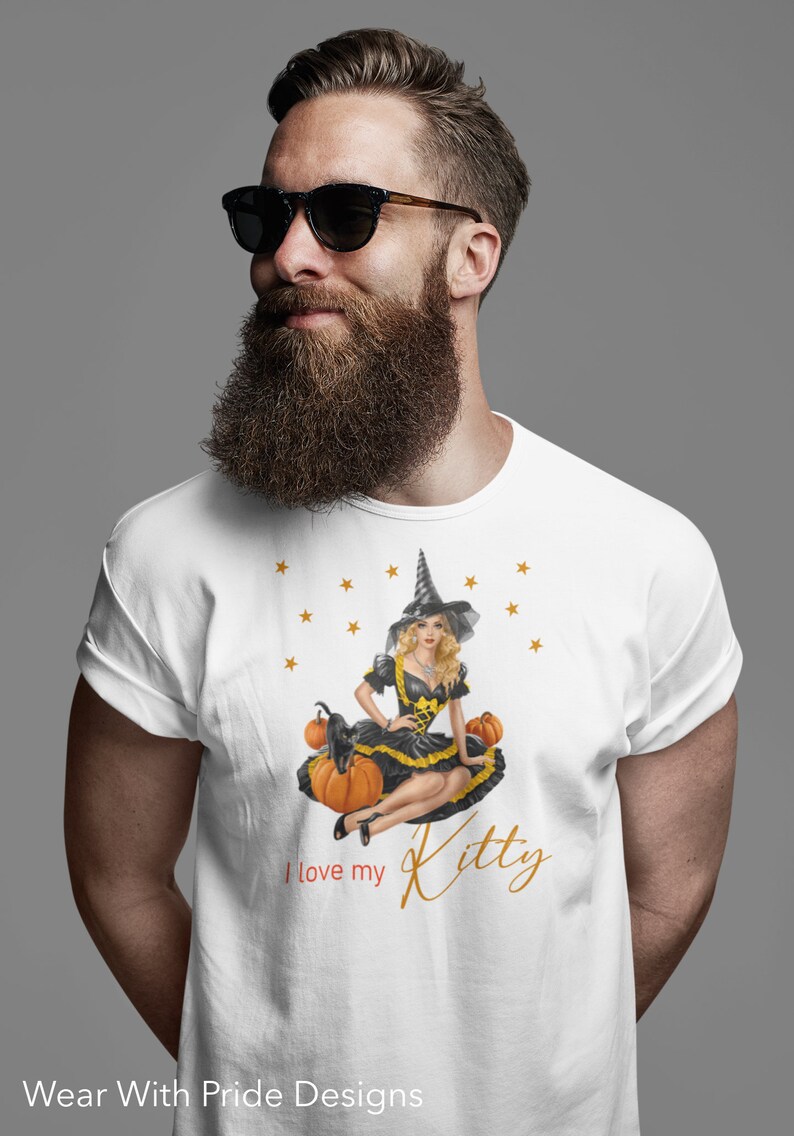 May include: White t-shirt with a graphic of a witch sitting on pumpkins with a black cat. The text "I love my Kitty" is printed on the shirt.