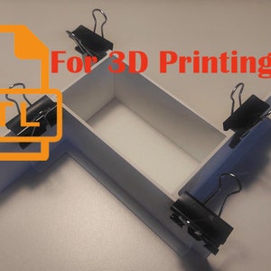 May include: A white cardboard box with four sides held together by binder clips. The box is labeled "For 3D Printing" and has a file icon with the letters "STL" inside.
