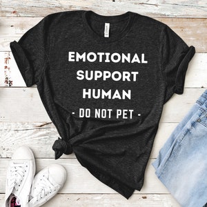 May include: A dark gray t-shirt with white text that reads "Emotional Support Human - Do Not Pet - "