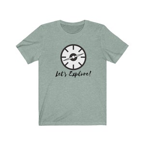 May include: A light green t-shirt with a black compass design and the text "Let's Explore!" printed on the front.