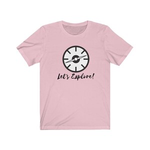 May include: Pink t-shirt with a black compass graphic and the text "Let's Explore!"