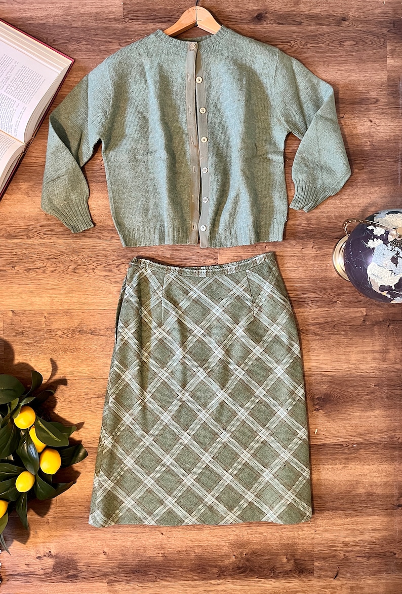 Puede incluir: Un c&aacute;rdigan de punto verde con cierre de botones en la espalda, combinado con una falda de cuadros verdes.