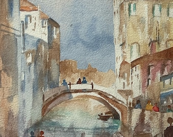 Puede incluir: Pintura a la acuarela de un paisaje urbano europeo con un puente sobre un canal. Los edificios en tonos beige, marrón y azul bordean el canal. Siluetas de personas están en el puente y a lo largo del canal. El cielo es una mezcla de azul y blanco.