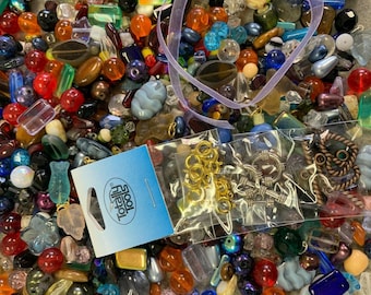Puede incluir: Un gran surtido de cuentas de vidrio de colores en varias formas y tamaños, incluyendo cuentas redondas, cuadradas y ovaladas. También hay algunas cuentas y hallazgos de metal en una bolsa separada etiquetada como "Tool File".