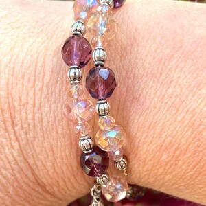 May include: A double-strand bracelet with silver beads and faceted glass beads in shades of pink and purple.