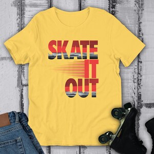 May include: Yellow t-shirt with the text "Skate It Out" in black, red, and gray lettering. The text is stylized with a red and gray stripe pattern.