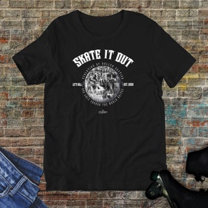 May include: Black t-shirt with a white graphic design featuring a vintage image of roller skaters. The graphic includes the text "Skate It Out", "Evolution of Roller Skating", "Let's Roll", "One Roll Around the World Unite", "Est. 2020", and "The Choppy".