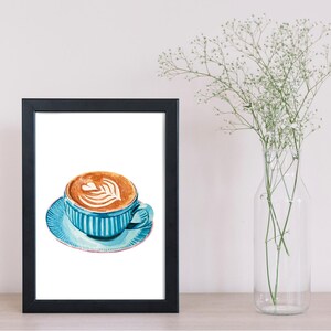 Może przedstawiać: Akwarela cappuccino w niebieskim kubku i spodku w pionowe paski, oprawiona w czarną ramę. Kawa ma wz&oacute;r w kształcie serca w piance. Po prawej stronie znajduje się przezroczysty szklany wazon z białymi kwiatami.