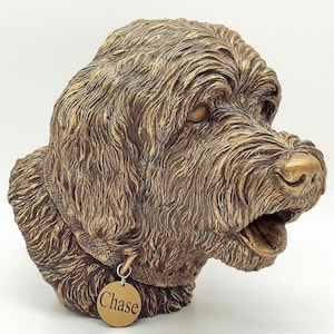 May include: A bronze sculpture of a dog's head with a collar and a tag that says "Chase".