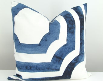 May include: A square throw pillow featuring a bold, geometric pattern in deep navy blue and crisp white. The design consists of thick, watercolor-style blue bands that form interlocking, angular shapes against a solid white background.