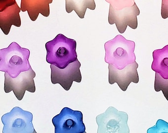Puede incluir: Una colección de 27 cuentas de vidrio en forma de estrella en varios colores, incluyendo transparente, amarillo, verde, naranja, rojo, rosa, morado, azul y azul claro.