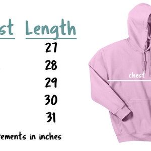 Op de afbeelding: Een lichtroze hoodie met een voorzak en capuchon. De afbeelding bevat een maattabel met borst- en lengtematen in centimeters: S (51 cm borst, 69 cm lengte), M (56 cm borst, 71 cm lengte), L (61 cm borst, 74 cm lengte), XL (66 cm borst, 76 cm lengte) en 2XL (71 cm borst, 79 cm lengte).