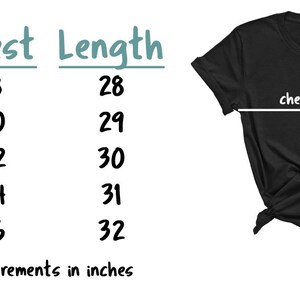 Op de afbeelding: Zwart T-shirt met maattabel en afmetingen in inches. Borstmetingen vari&euml;ren van 45.7 tot 66 cm en lengtemetingen van 71.1 tot 81.3 cm. De shirtmaten zijn S, M, L, XL en 2XL.