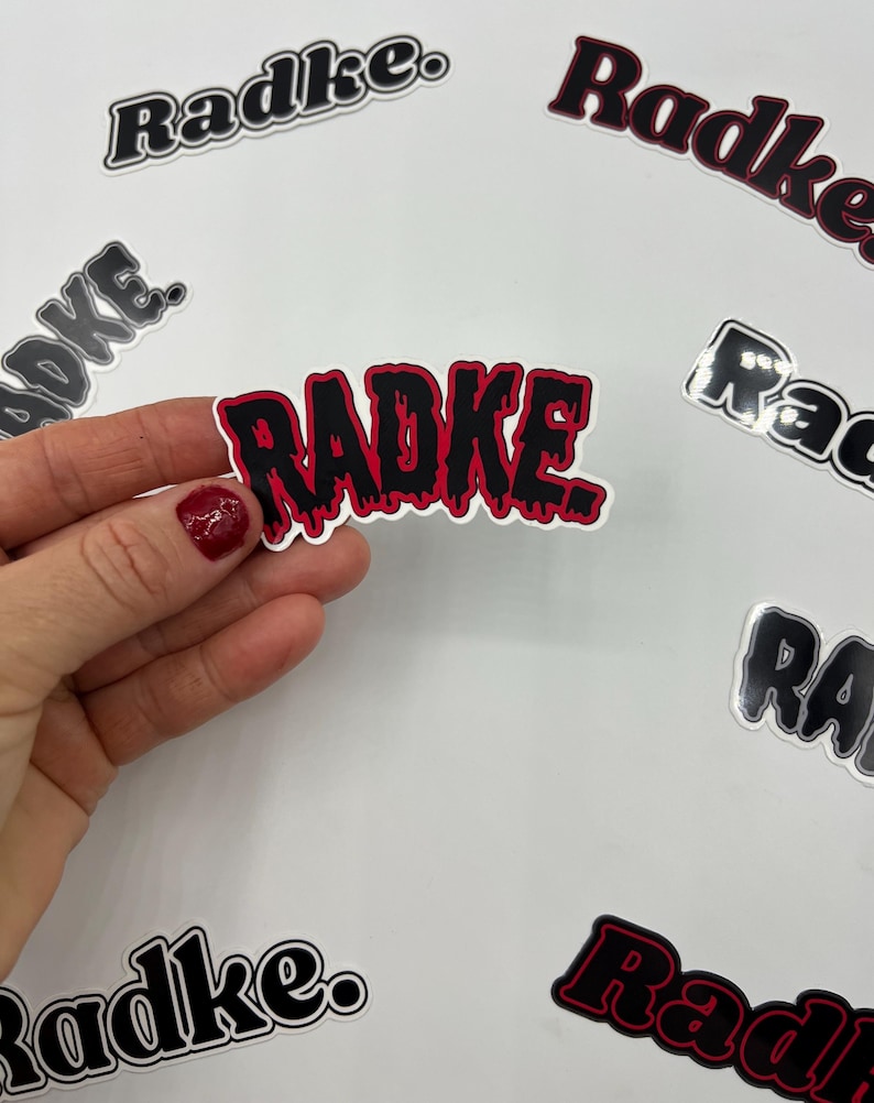 May include: A collection of stickers with the word "Radke" in different styles. One sticker features the word in a dripping, black and red font.